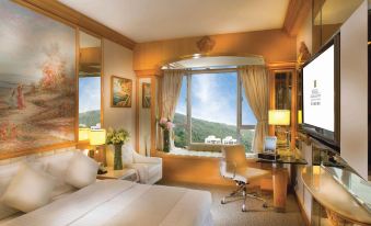 The bedroom features large windows and a bed in the center, with an open space beside it at Regal Hongkong Hotel