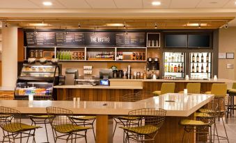 a modern café with a bar area and a long counter filled with various drinks at Courtyard Yonkers Westchester County