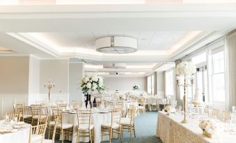 a large banquet hall with multiple tables and chairs , set up for a formal event at The Inn at Harbor Shores