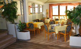 a dining room with several tables and chairs arranged for a group of people to enjoy a meal together at Hotel Sonnenblick