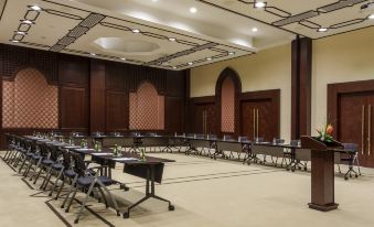 a large conference room with multiple rows of chairs arranged in a semicircle , providing seating for attendees at Kempinski Hotel Soma Bay