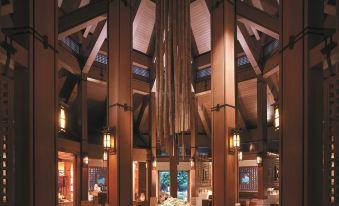 a large , wooden building with high ceilings and tall columns , decorated with a flower arrangement in the center at Shangri-La Boracay