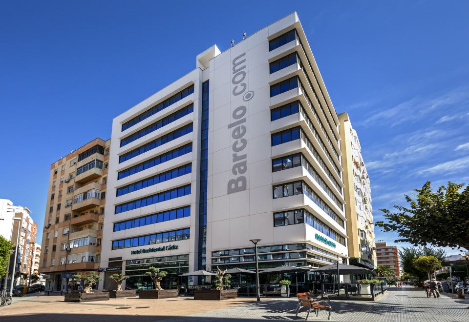 "a modern building with the name "" barcello "" on it , located in a bustling city street" at Occidental Cádiz
