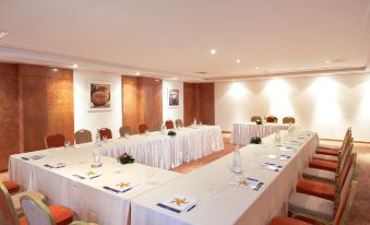 a long table with white tablecloths and place settings is set up in a conference room at Iberostar Selection Royal El Mansour