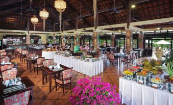 a large dining room with multiple tables and chairs arranged for a group of people to enjoy a meal together at Pandanus Resort