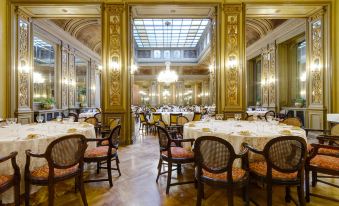 a large , elegant dining room with many tables and chairs arranged for a formal event at Grand Hotel Et des Palmes