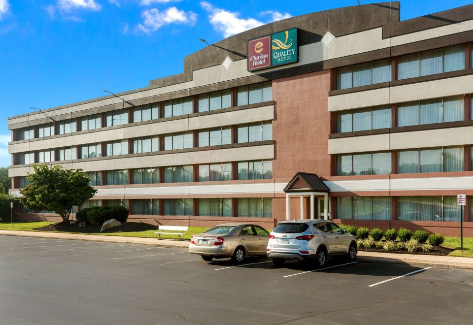 a large hotel building with multiple floors , located in a city setting with cars parked outside at Chester Hotel and Conference Center