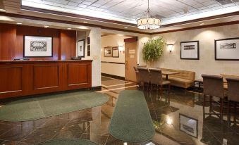 a modern office lobby with a reception desk , couches , and tables , as well as framed pictures on the walls at Best Western the Inn at Ramsey