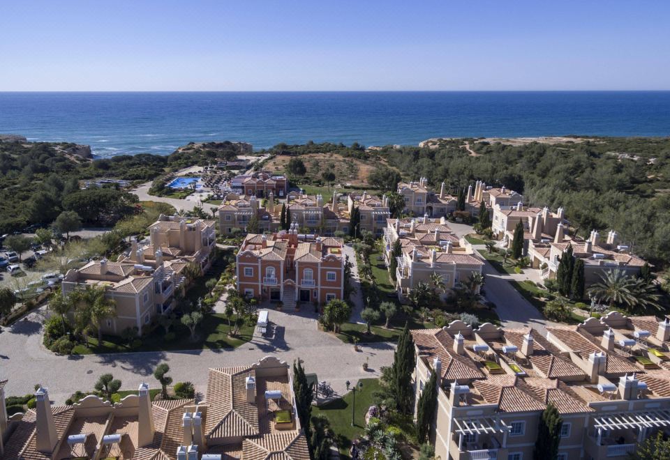 aerial view of a large , well - maintained residential area near the ocean , with multiple buildings and a car parking lot at Vila Alba Resort