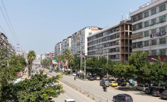 At an intersection, there is a city street lined with parked cars and buildings on the other side at Guohui Hotel (Fuzhou Jinfeng Hotel)