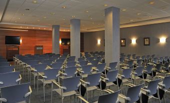 a conference room with rows of chairs arranged in a semicircle , and a podium at the front at Globales Almirante Farragut