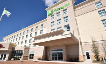 a large hotel with a large parking lot in front of it , surrounded by trees at Holiday Inn Cincinnati N - West Chester