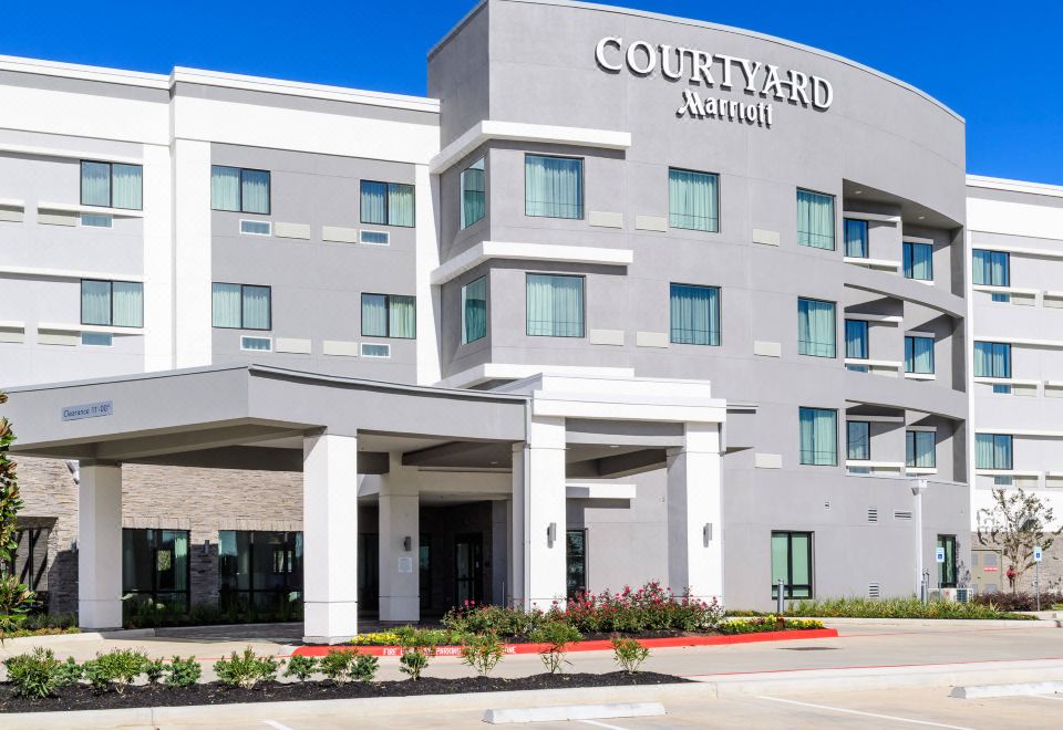 a large , modern hotel building with multiple stories and a courtyard marriott logo on the front at Courtyard Lake Jackson