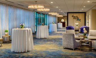 a well - decorated banquet hall with tables covered in white tablecloths , chairs , and a piano in the background at Crowne Plaza Boston - Woburn, an IHG Hotel