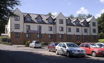 a row of buildings with cars parked in front of it and a sign on top at Premier Inn Glasgow (Bearsden)