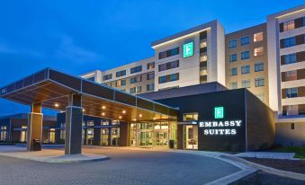 an exterior view of a hotel building , featuring a large sign above the entrance and a walkway leading to it at Embassy Suites by Hilton Plainfield Indianapolis Airport