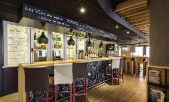 a restaurant with a bar and dining area , featuring a variety of chairs and tables at Ibis Mulhouse Bale Aeroport