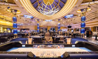 a large , elegant casino with multiple gaming tables and a blue dome ceiling , decorated for a formal event at Kings Casino & Hotel