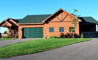 a large , brown house with a green garage door and a grassy yard in front at Agaming Golf Resort