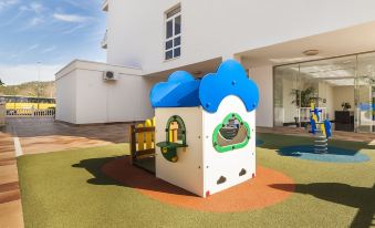 a small playground with a blue and white play structure , located in a residential area at Globales Palmanova