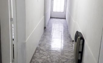 a hallway with a white wall and floor , a door on the right side , and an air conditioner mounted on the wall at Casa Mendoza