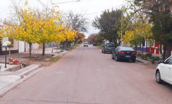a street with trees on both sides and cars parked in the middle , lined with a building at Casa Mendoza