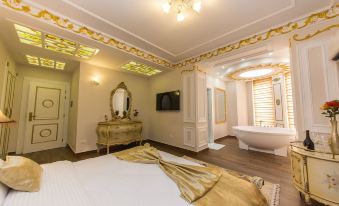 a luxurious bedroom with a large bed , a bathtub , and a chandelier hanging from the ceiling at Hotel Empire Albania