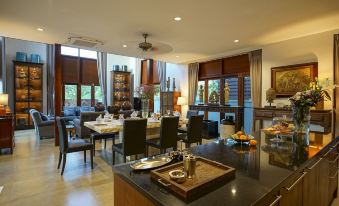 a spacious living room with a dining area , featuring a large table and chairs , couches , and windows at Mae Rim Grace