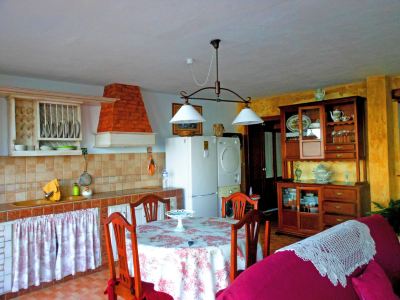 a well - equipped kitchen with a dining table and chairs , as well as a living room area at Titi Titi Photo