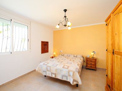 a bedroom with a white bed , yellow walls , and a wooden dresser near the window at Joli Joli Photo