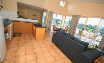 a spacious living room with a dining area and a kitchen , all connected by a kitchen island at Lennox Beach Resort
