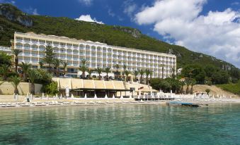 a large hotel situated on the beach , surrounded by lush greenery and clear blue water at Louis Ionian Sun