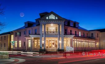 a large building with a crescent moon in the sky , surrounded by trees and cars on a street at night at The Inn at Wise