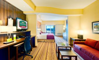 "a hotel room with a bed , couch , tv , and desk , along with the words "" courtyard by marriott "" on the screen" at Courtyard Houma