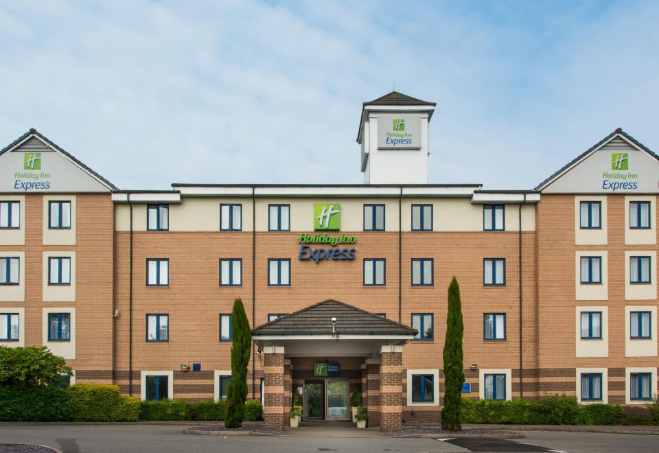 "a large hotel building with a green sign that reads "" holiday inn express "" prominently displayed on the front" at Holiday Inn Express London - Dartford