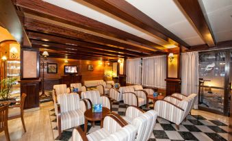 a spacious room with wooden walls and ceiling , filled with rows of white and brown striped chairs arranged in a v - shape at THB Felip - Adults Only