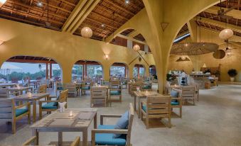 a large dining room with wooden tables and chairs arranged for a group of people to enjoy a meal together at Lahana Resort Phu Quoc & Spa