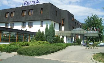 a large building with a black and white color scheme , surrounded by trees and other buildings at Hotel Atlantis