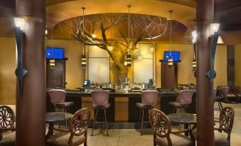a bar area with multiple chairs and tables , as well as a television mounted on the wall at Desert Diamond Casino