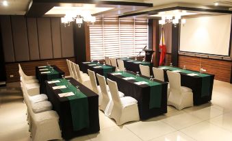 a conference room with rows of chairs arranged in a semicircle , and a projector on the wall at Brentwood Suites