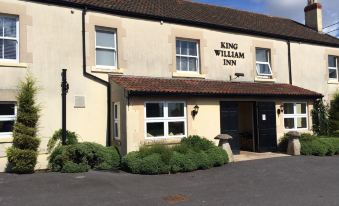 "a brick building with a sign that reads "" king william inn "" prominently displayed on the front of the building" at King William Inn
