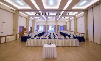 a large conference room with multiple tables and chairs arranged for a meeting or event at Alkyon Resort Hotel & Spa