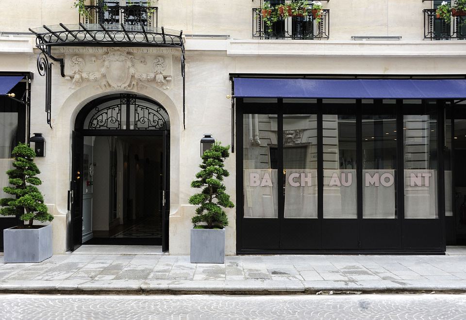 a building with a black storefront and a blue awning is shown in the image at Hotel Bachaumont