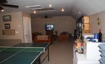 a ping pong table is set up in a room with a television and other items at A Mighty Oak B&B