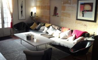 a cozy living room with a large sectional couch , a coffee table , and various decorative items at Le Numero 15