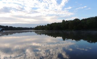 a serene lake with a cloudy sky reflected in the water , creating a picturesque scene at Cookie B