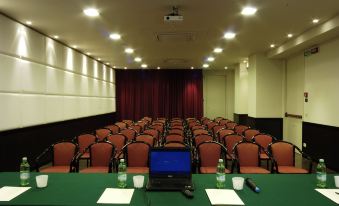 a conference room with rows of chairs and a laptop on a table , ready for a meeting or presentation at El Patio Hotel