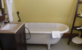 a white bathtub with a towel on the side is next to a sink and an electrical outlet at Seafarer Inn