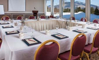 a conference room set up for a meeting , with tables and chairs arranged in rows at White Mountain Hotel and Resort