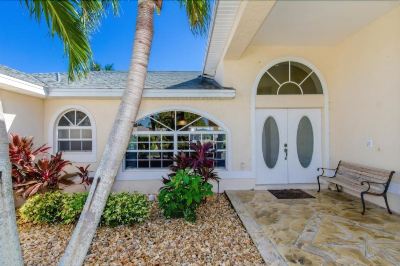 a white house with a large white door and a palm tree in front of it at Italy